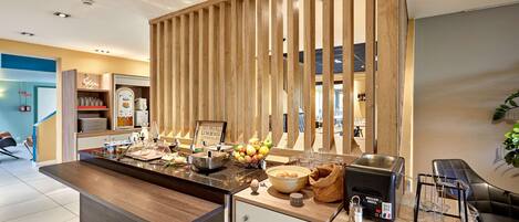 A modern kitchen with a wooden island, breakfast bar, and coffee machine.
