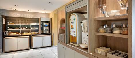 A modern cafe with a self-serve coffee station, a variety of pastries, and a clean, minimalist design.