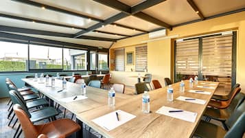 A conference room with a long table, chairs, water bottles, and papers.