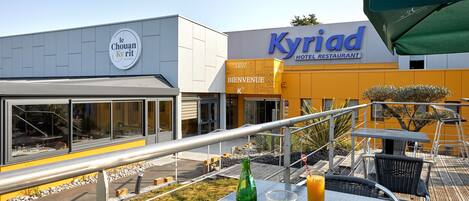 Exterior de un hotel con un letrero que dice 'Kyriad Hotel Restaurant' y 'Le Chouan Kyrit'.
