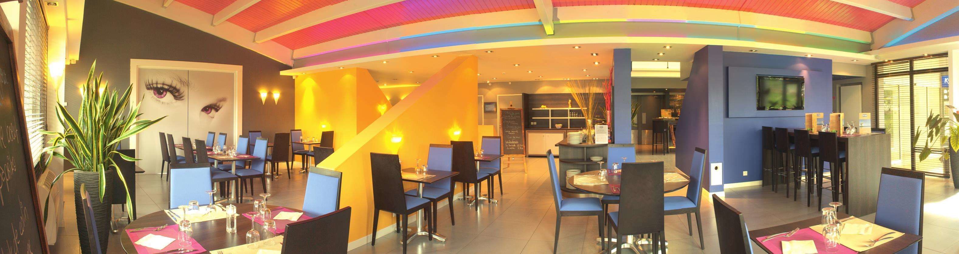 En modern restaurang med ett iögonfallande tak, flera olika matplatser och en bar.