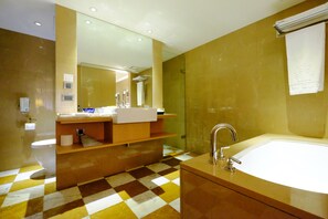 Ein modernes Badezimmer mit Fußboden in Schachbrettoptik, einem großen Spiegel, einem Waschbecken und einer Badewanne.