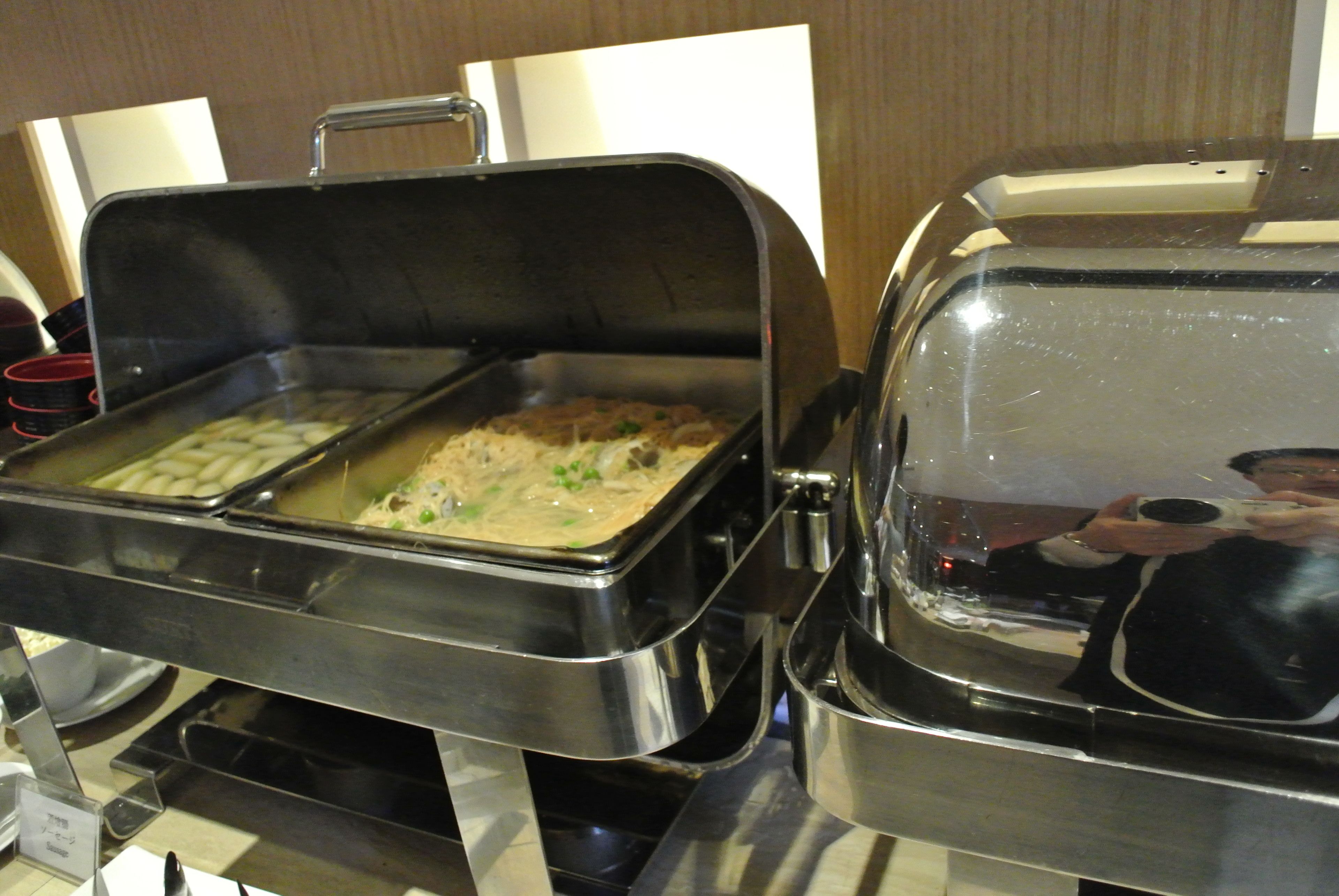 A buffet setup with a variety of food items and a covered serving station.