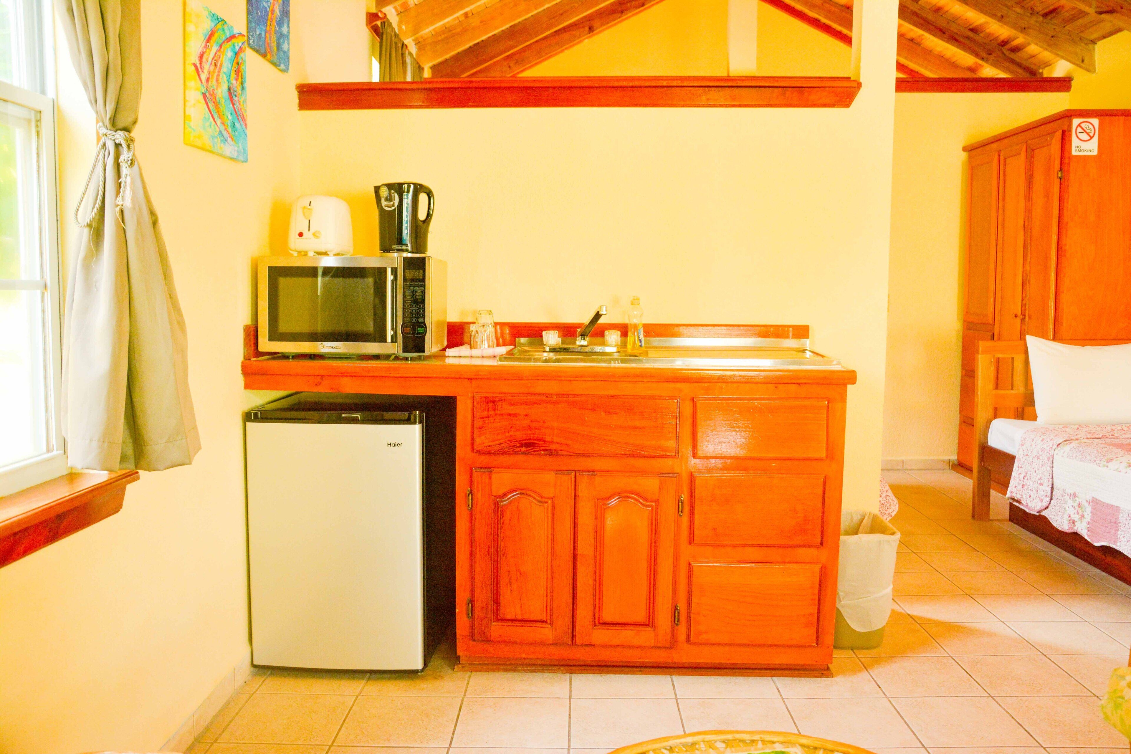 Una cocina compacta equipada con refrigerador, microondas y cafetera.