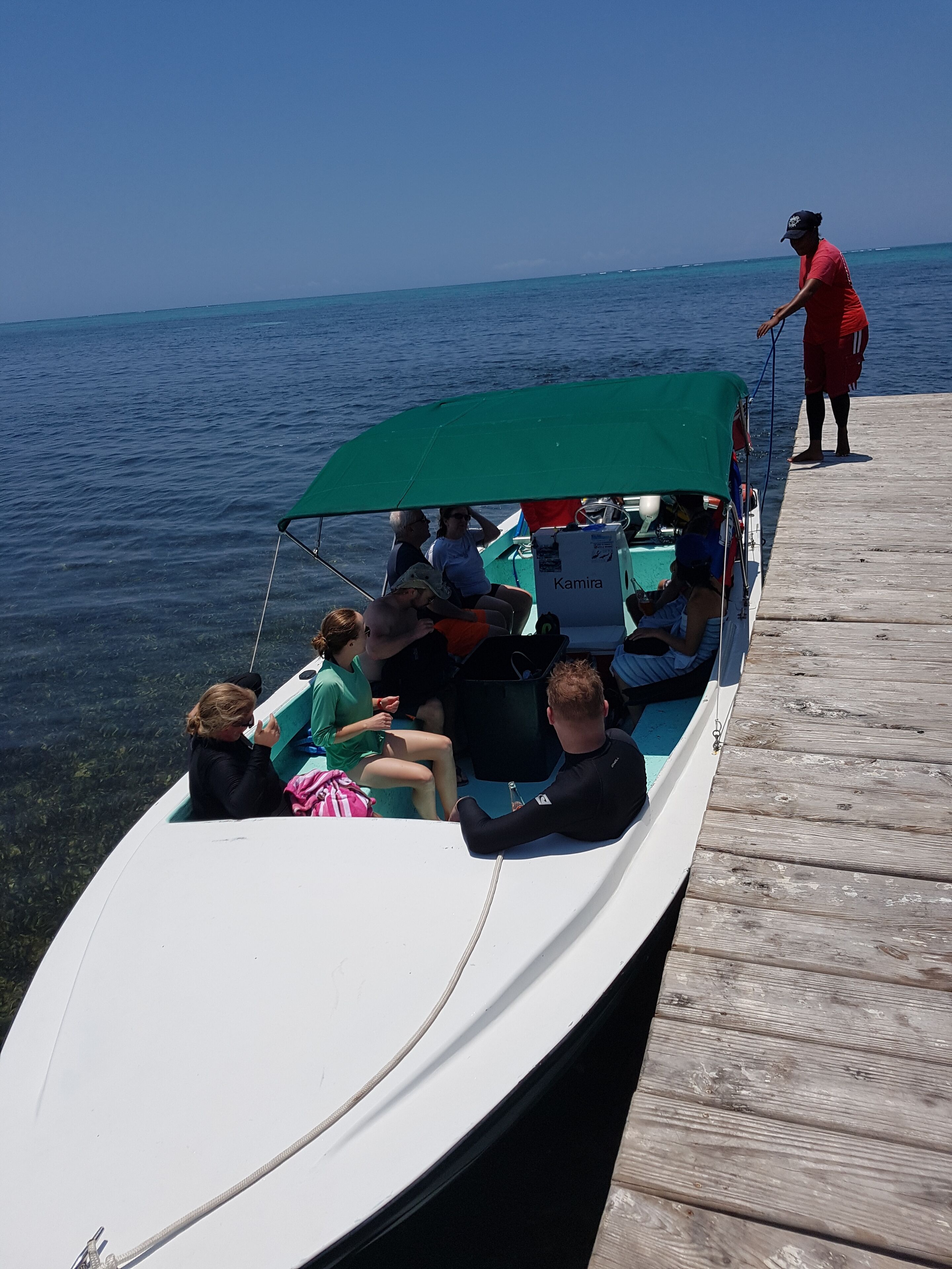 A boat with passengers and a person standing on a dock.