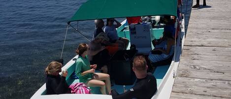 A boat with passengers and a person standing on a dock.
