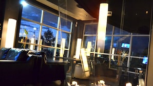 A modern hotel room with large windows, a leather sofa, and a fireplace. - Grand Times Hotel Quebec City Airport (L'Ancienne-Lorette)