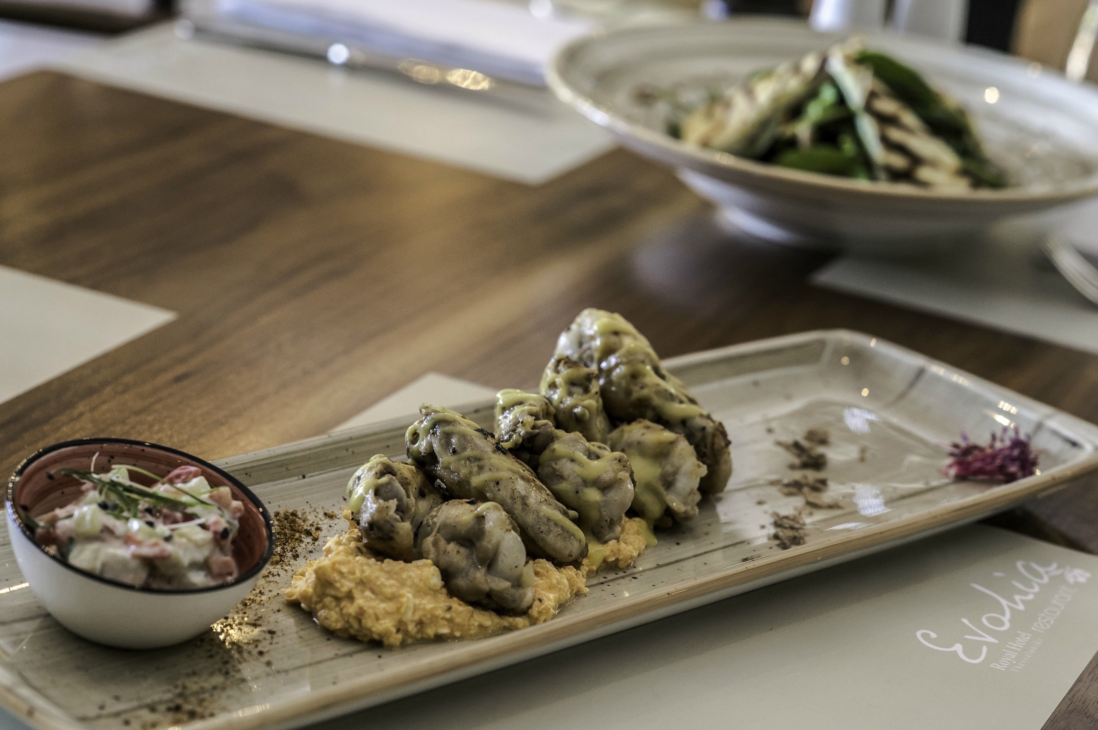 Un plato de comida con albóndigas y un acompañamiento, posiblemente una ensalada, sobre una mesa.