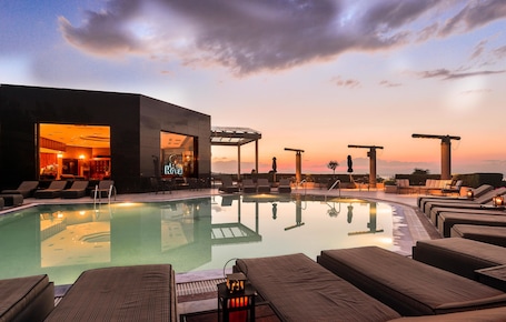 Una piscina al aire libre de temporada, sombrillas