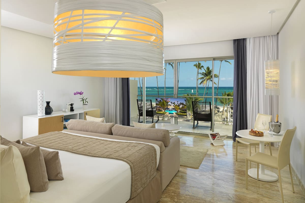 Relax in this serene beachfront retreat with a large bed, balcony, and stunning ocean views.