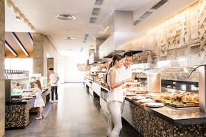 A buffet setup with various food items and a modern interior design.