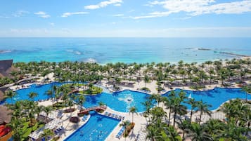 Relax by the large central pool surrounded by palm trees and sun loungers, with access to the beach and ocean views.