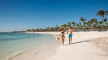On the beach, white sand, sun loungers, beach towels