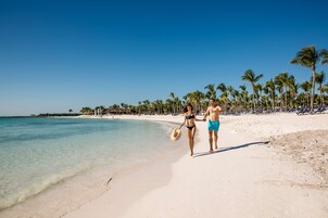 On the beach, white sand, sun loungers, beach towels