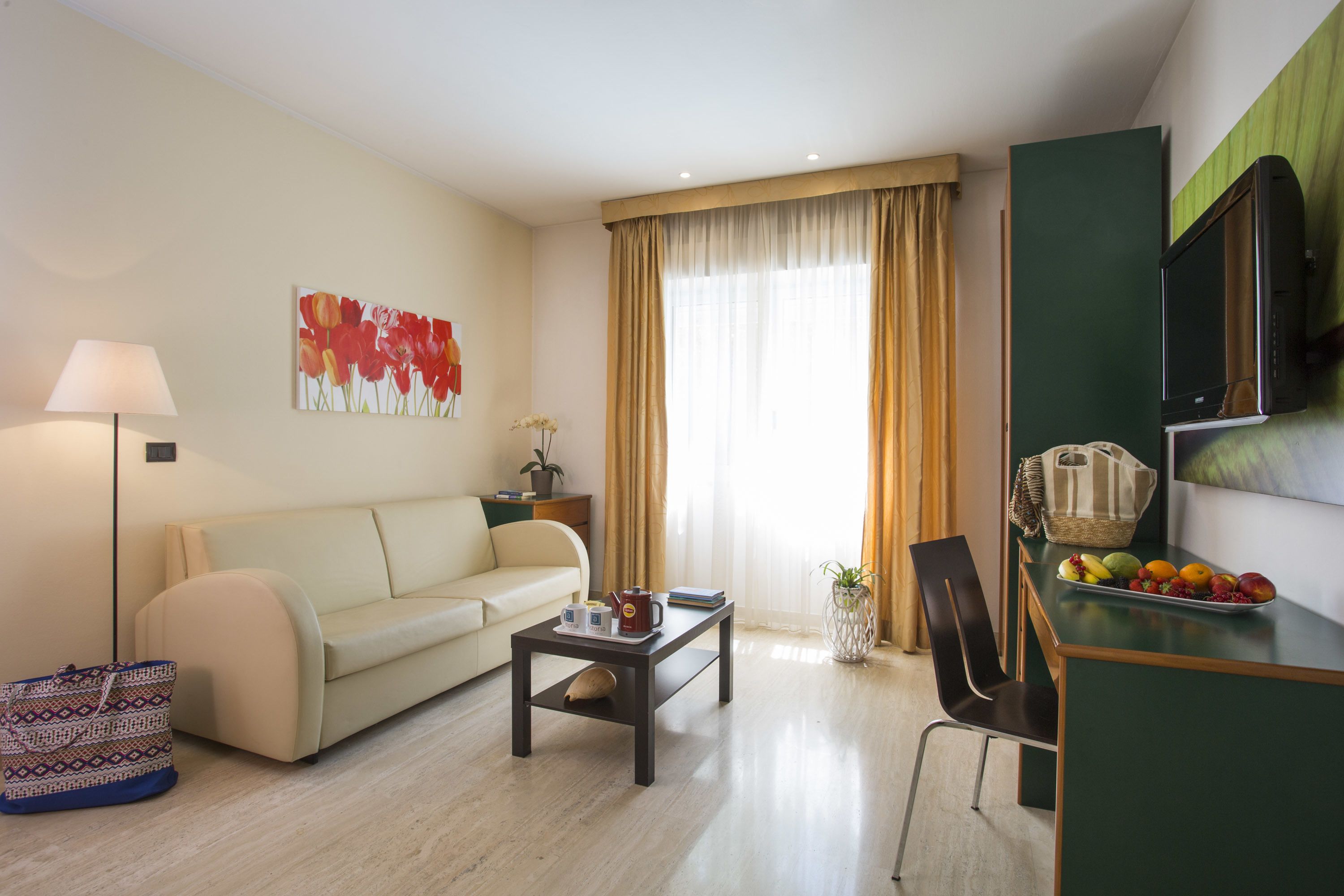 A modern living room with a sofa, coffee table, and a flat-screen TV.