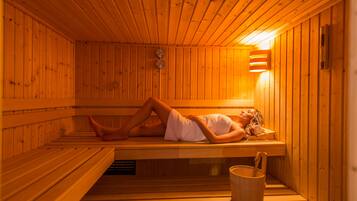 A sauna with wooden benches and a wall-mounted heater.