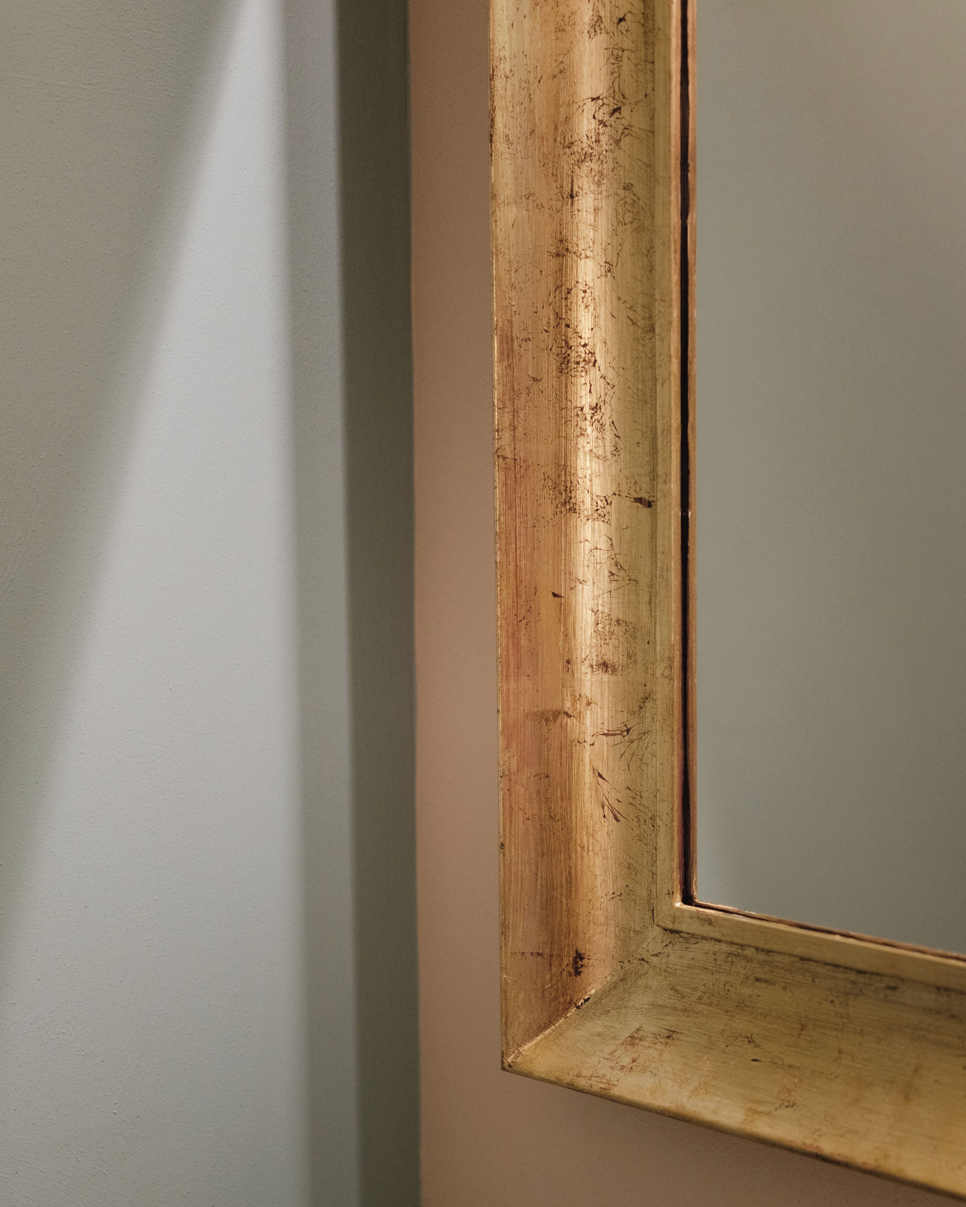 Una esquina de una habitación con un marco de madera y una pared lisa.
