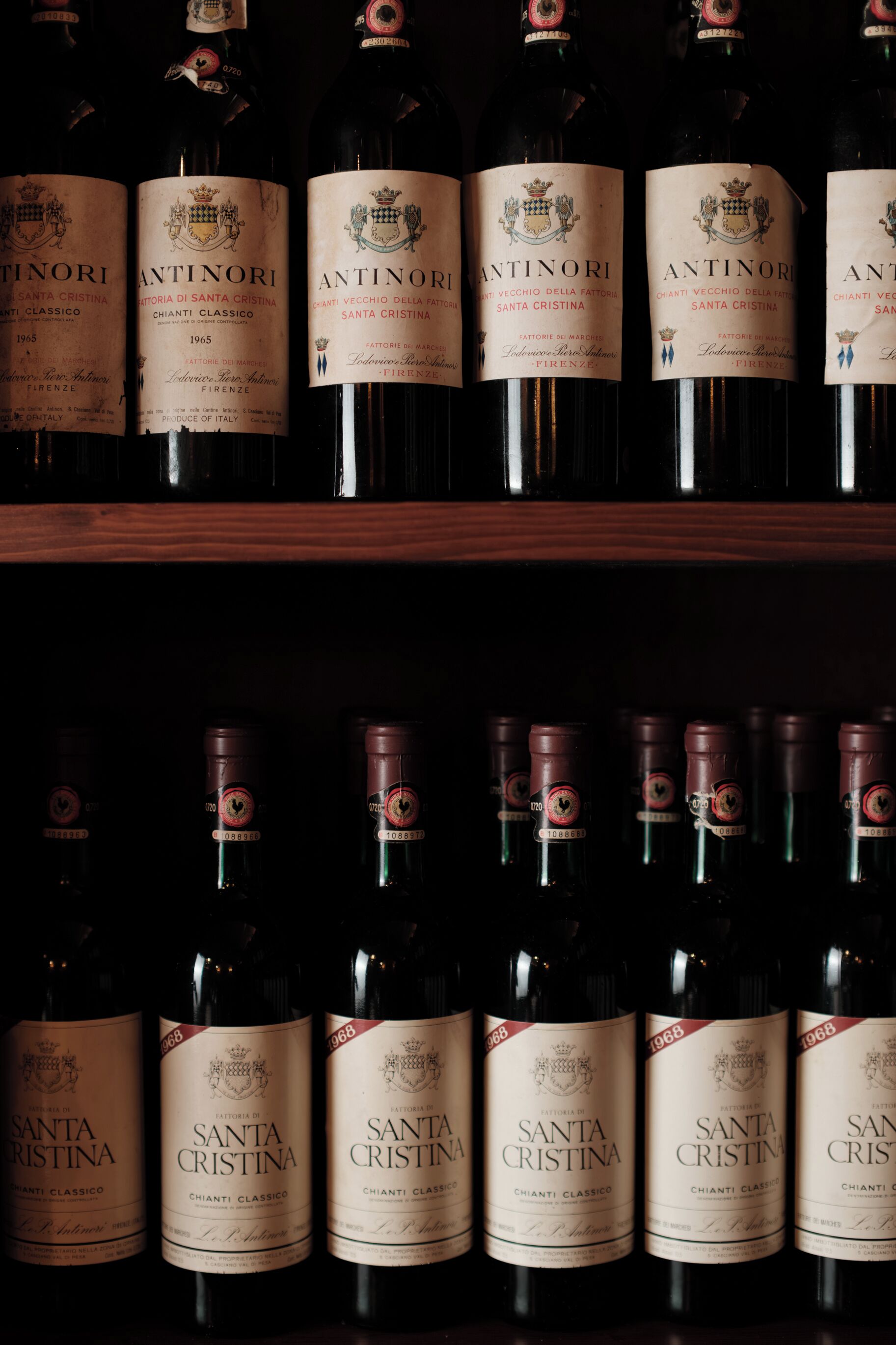 Rows of wine bottles with labels, arranged on shelves.