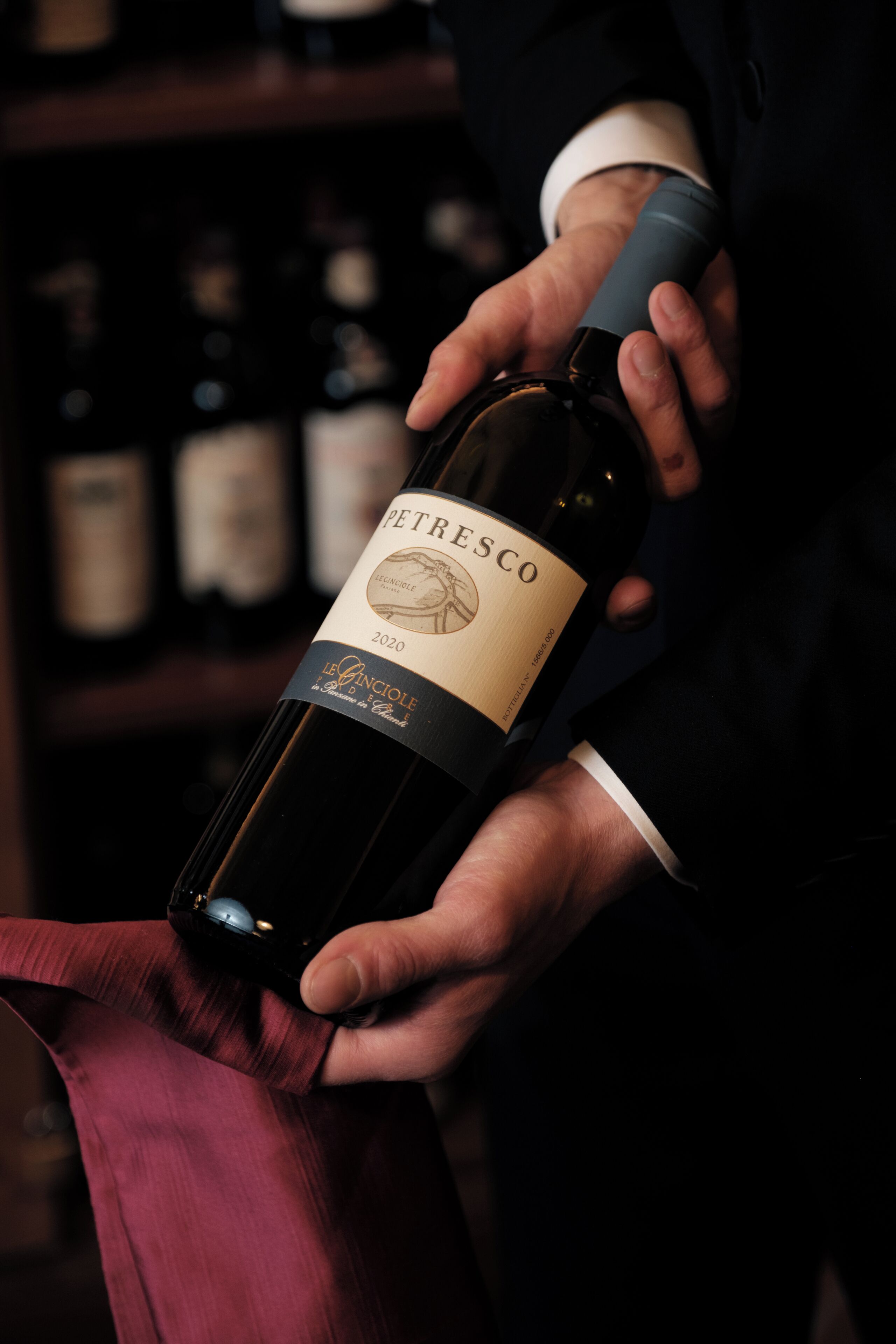 Une personne tenant une bouteille de vin Petrésco.