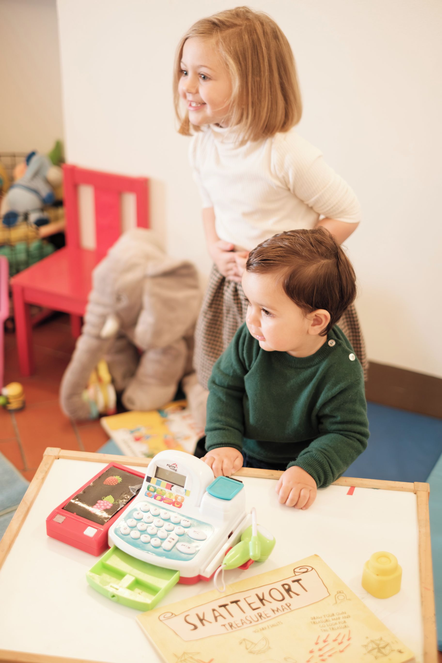 Duas crianças brincando com brinquedos em cima de uma mesa.