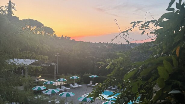 A resort with a pool area, umbrellas, and a stage for events. - Villa Castiglione (Impruneta)