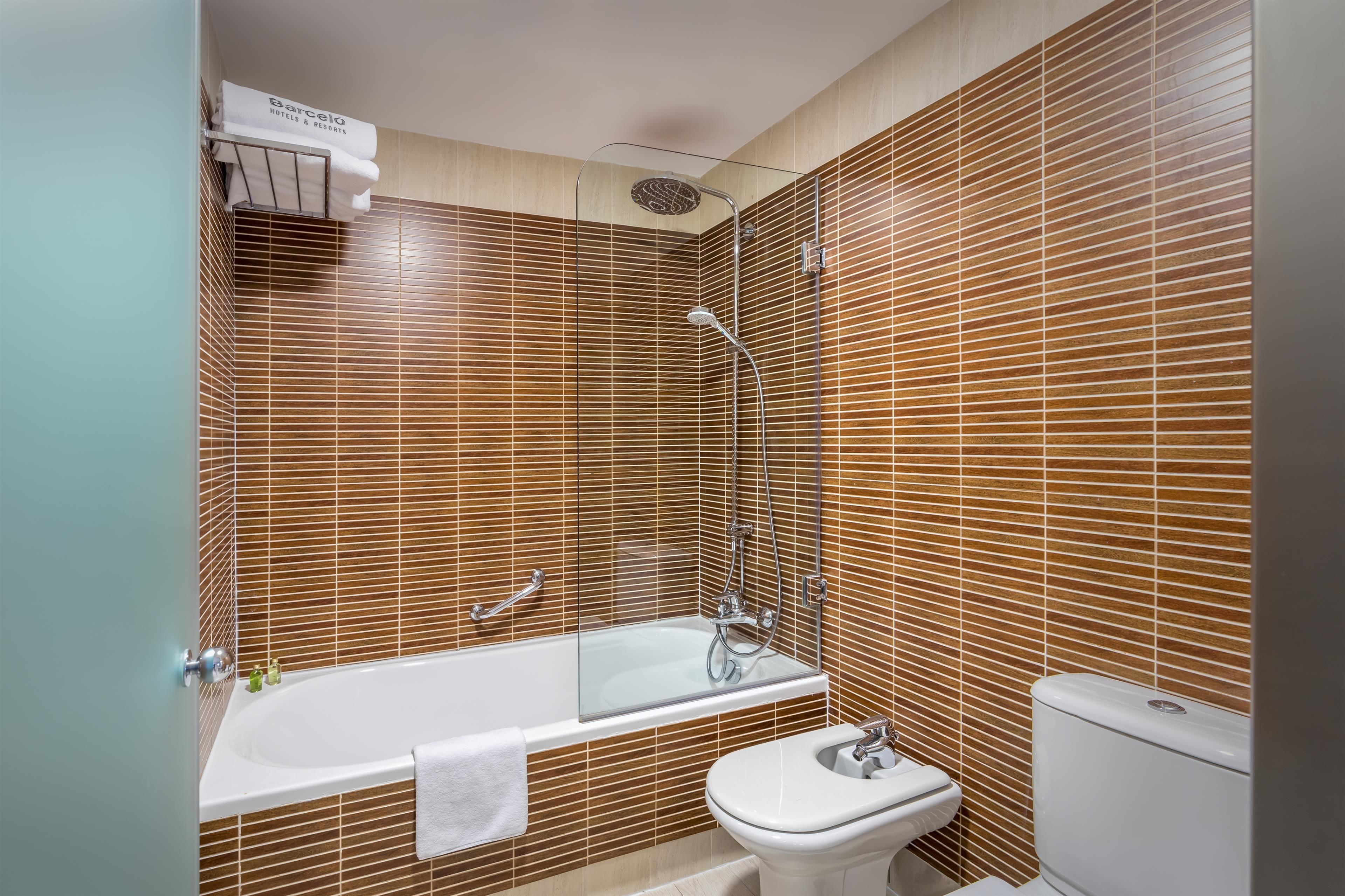 Une salle de bain moderne équipée d’une baignoire, de toilettes et d’un espace douche.