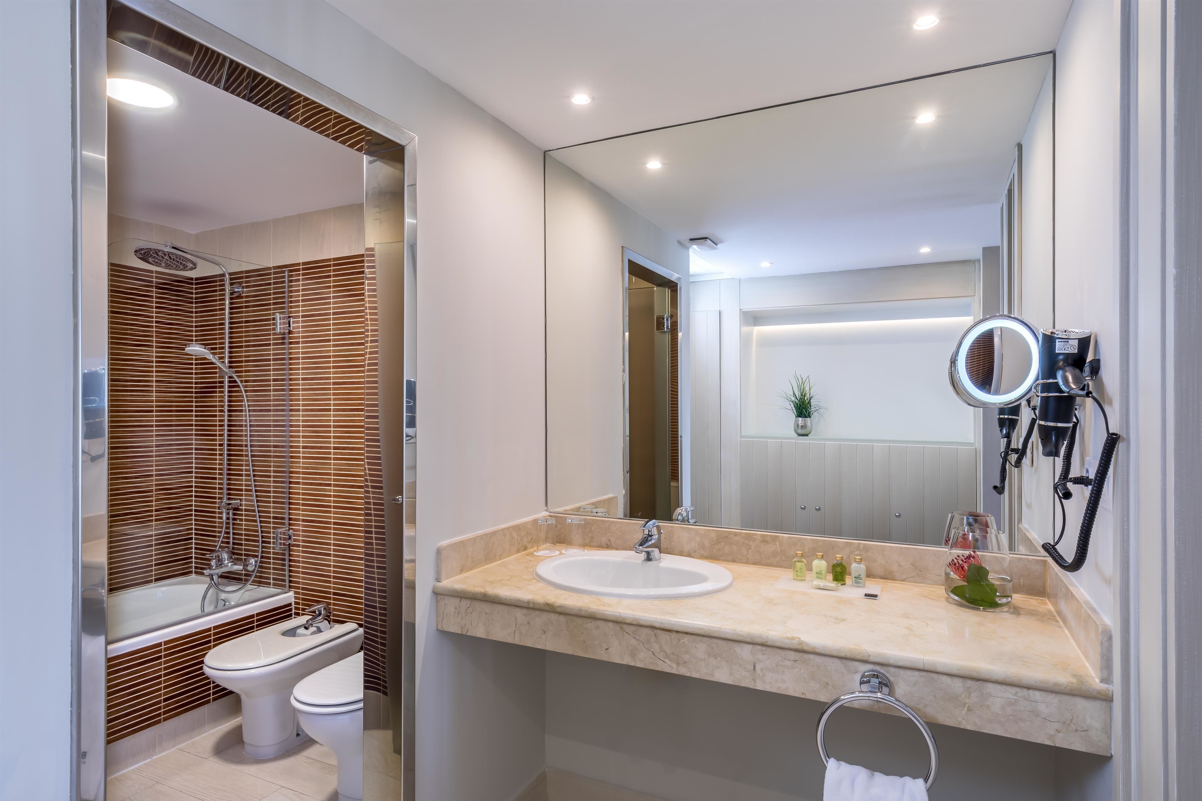 A modern bathroom with a bathtub, toilet, and sink.