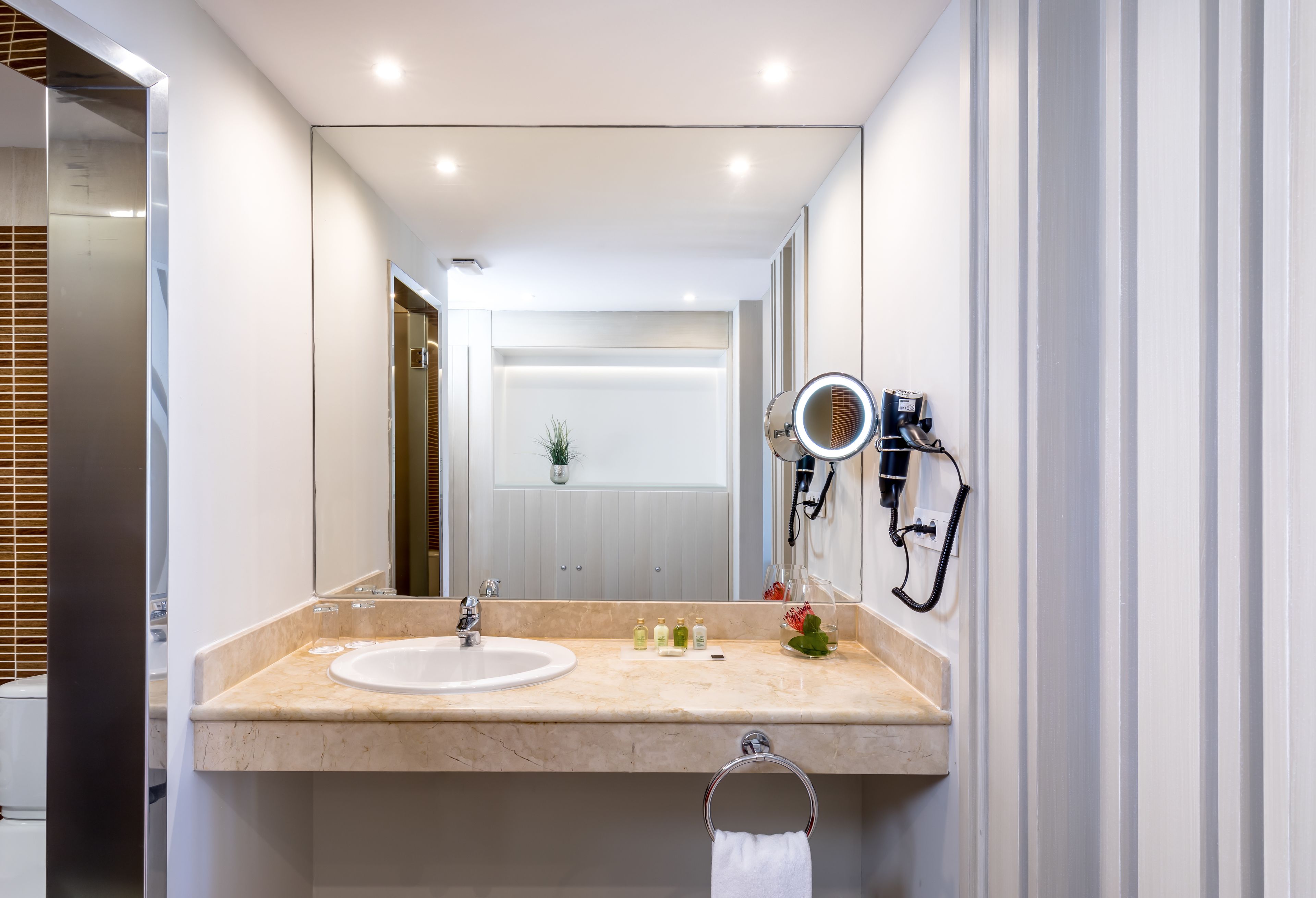 A modern bathroom with a large mirror, a sink, and a vanity.