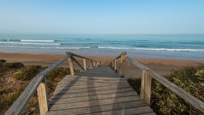 Una pasarela de madera que conduce a una playa con olas.