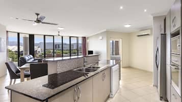 A modern kitchen with a large island, stainless steel appliances, and a view of the city.