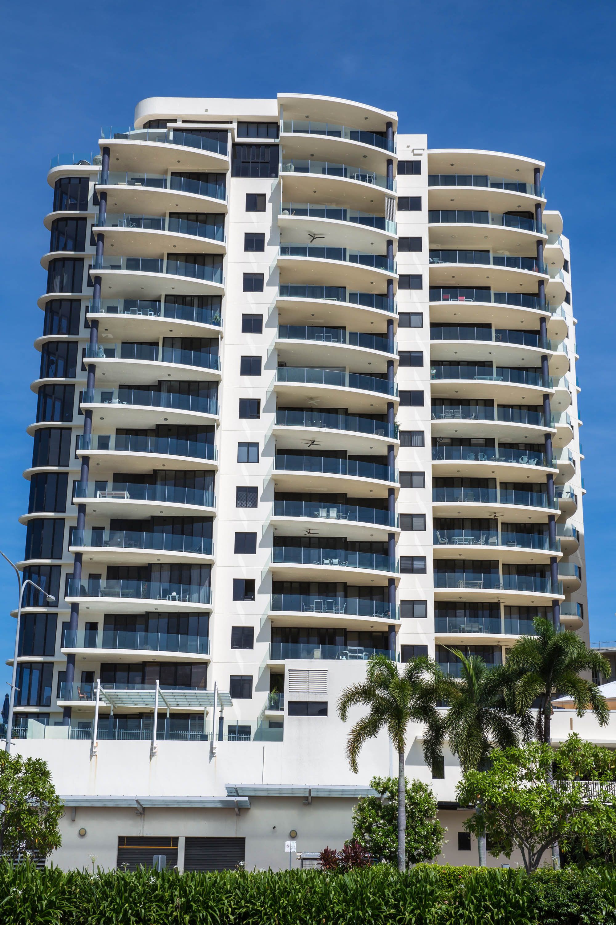 Un hotel moderno de gran altura con múltiples balcones y un cielo despejado.
