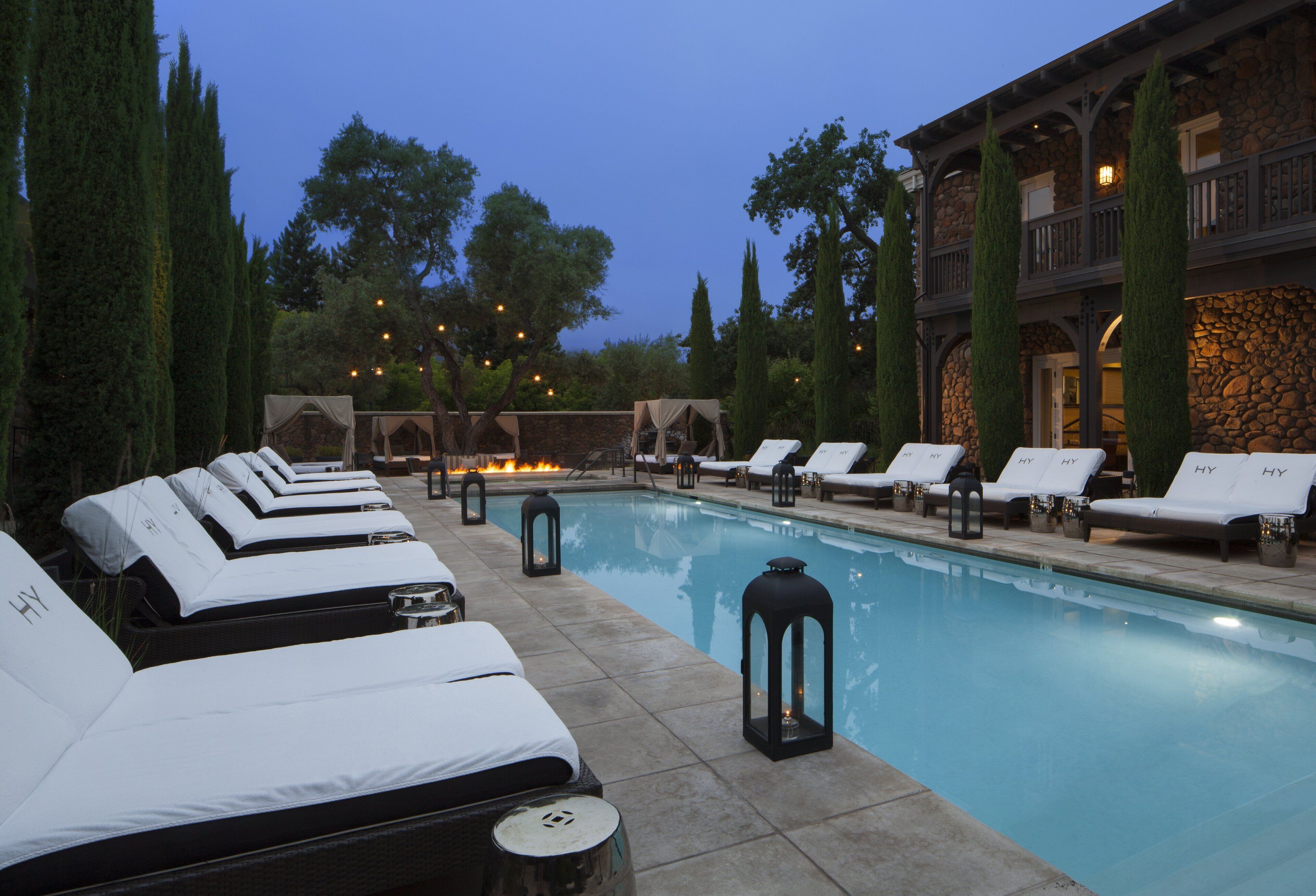 A poolside area with lounge chairs and a stone building in the background.