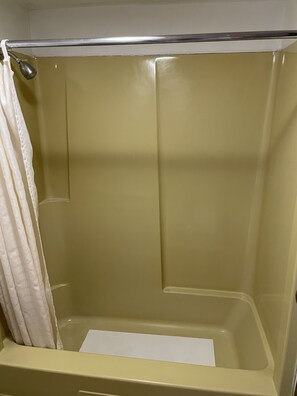 A shower with a beige interior, a shower curtain, and a metal grab bar. - Budget Host Inn Greenup (Greenup)