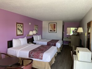 A hotel room with two beds, a desk, a chair, a microwave, and a mirror. - Budget Host Inn Greenup (Greenup)