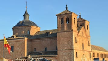 Un edificio histórico con una destacada torre de campanas y una cúpula, que presenta un asta con una bandera.