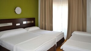 A hotel room with two beds, a green wall, and a window with curtains. - Sercotel Las Estrellas (Ciempozuelos)
