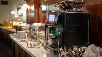 Um espaço com estação de café, máquina de café, chávenas e utensílios.