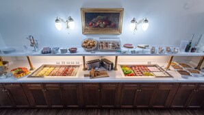 A buffet setup with various food items and a painting on the wall. - Hotel Liberty (Prague)