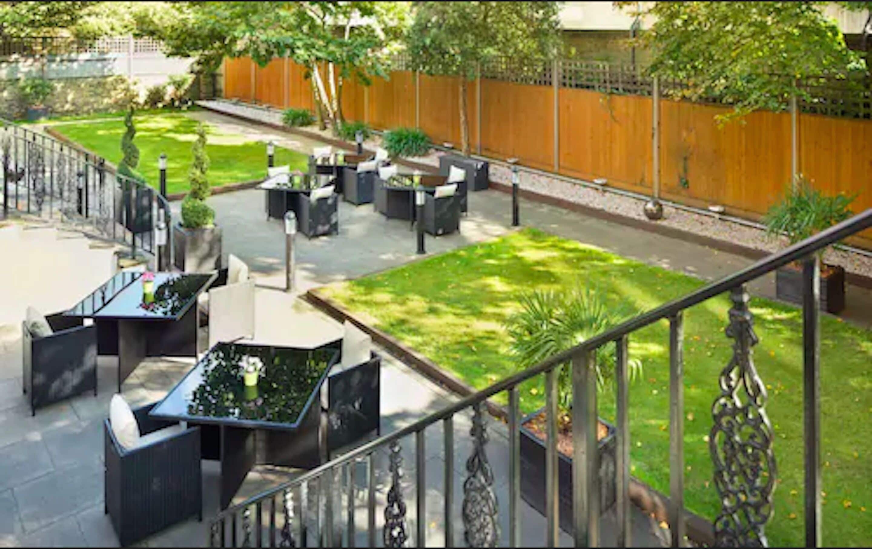 An outdoor patio area with seating arrangements and a small lawn.
