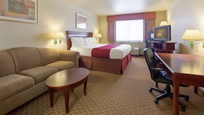 Hotelkamer met een bed, een slaapbank, een bureau, een stoel, een televisie en een lamp.