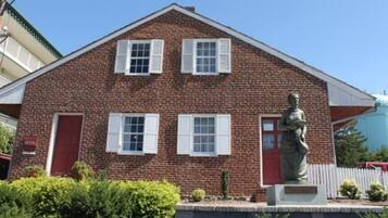 Un bâtiment en briques avec une statue devant.