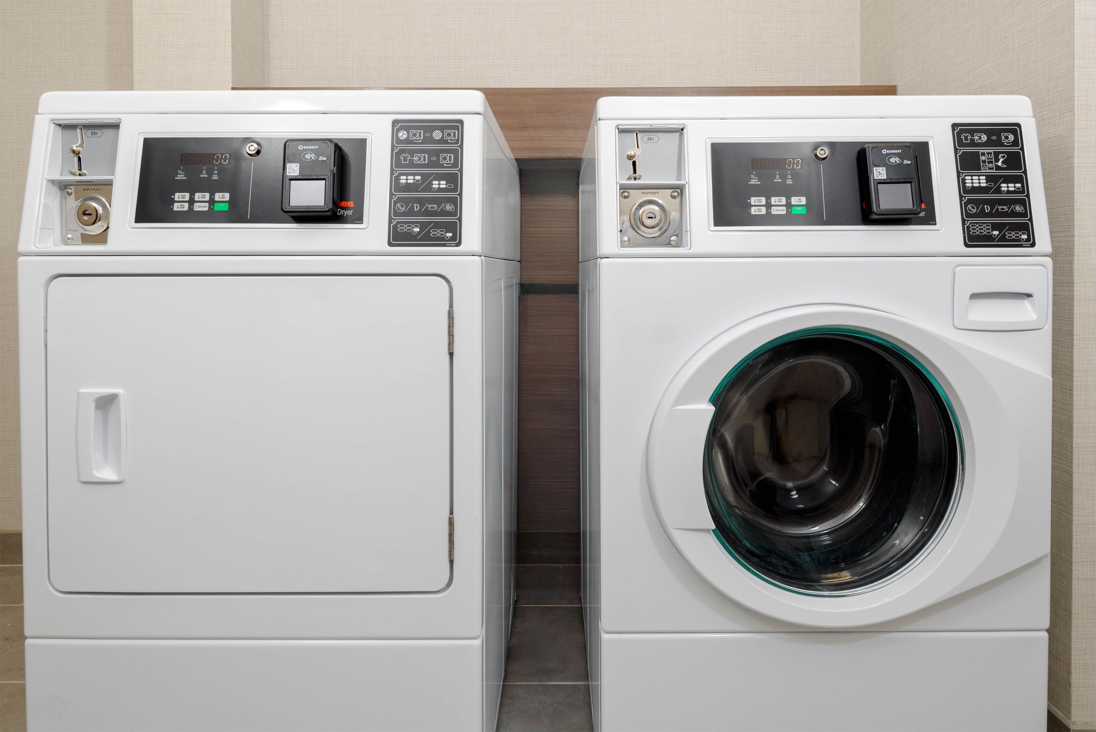 Two front-loading washing machines side by side in a laundry room.