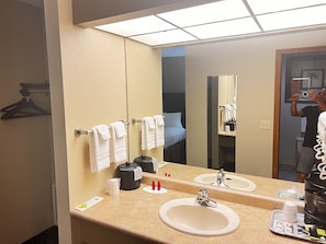 Bathroom features a double sink, coffee maker, and towel rack.
