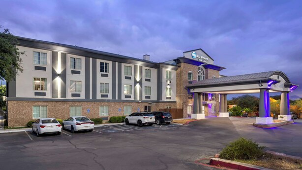 Ein Hotel mit modernem Design, inklusive überdachter Parkgarage und mehreren Stellplätzen.