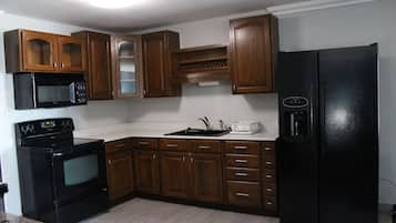Suite, varias camas | Cocina privada | Frigorífico, microondas y cafetera o tetera