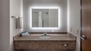 A bathroom with a granite countertop, a sink, a mirror, and a towel rack. - Holiday Inn Express & Suites Grenada by IHG (Grenada)