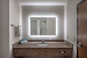 A bathroom with a granite countertop, a sink, a mirror, and a towel rack. - Holiday Inn Express & Suites Grenada by IHG (Grenada)
