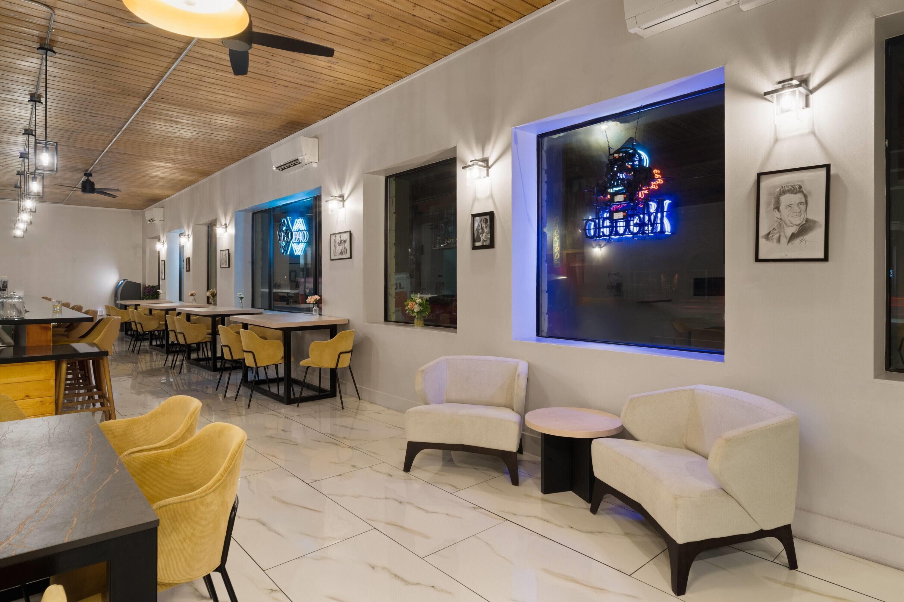 Un intérieur moderne avec un bar, des sièges et des œuvres d’art accrochées aux murs.