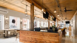 A modern interior with a wooden reception desk, bar area, and seating. - The Hotel Pendleton, Trademark Collection by Wyndham (Pendleton)