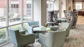 A modern lounge area with comfortable seating, large windows, and a view of the outdoors. - Residence Inn Houston West-Energy Corridor (Houston)